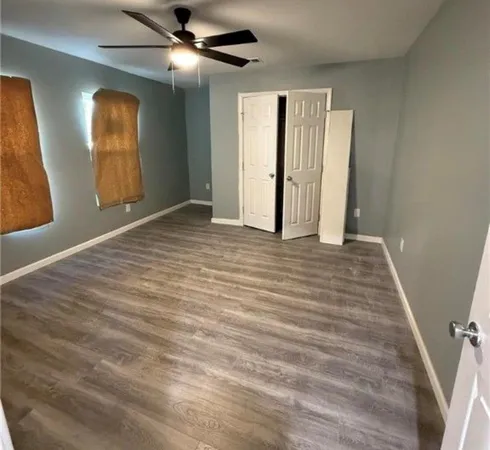 a view of an empty room with closet and a window