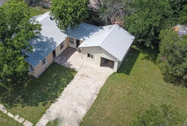 an aerial view of a house with a yard and trees