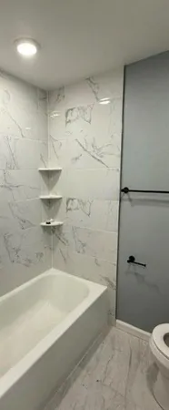 a bathroom with a bathtub and toilet