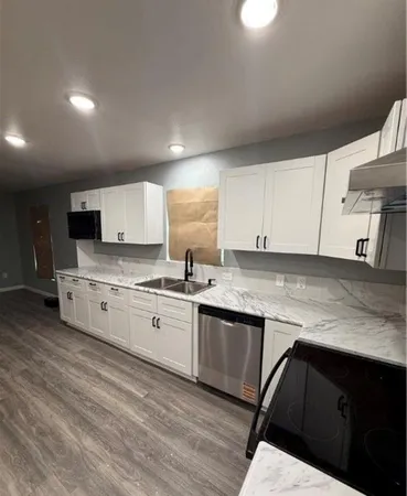 a kitchen with granite countertop white cabinets and white appliances