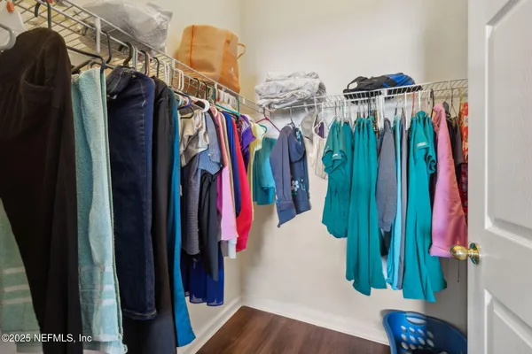 a view of walk in closet with clothes