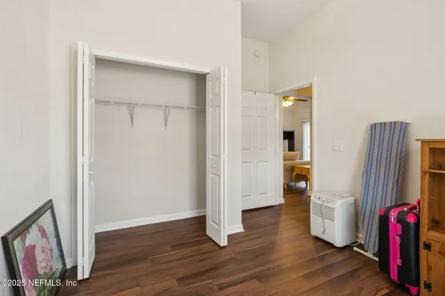 a view of an empty room with wooden floor and a flat screen tv