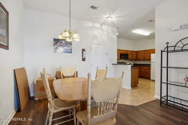 a dining room with furniture a chandelier and wooden floor