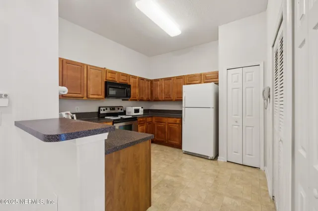 a kitchen with a refrigerator a stove top oven a sink and cabinets