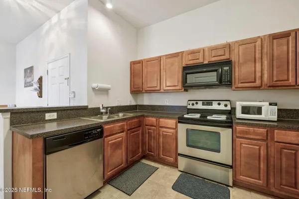 a kitchen with stainless steel appliances granite countertop a sink stove and microwave