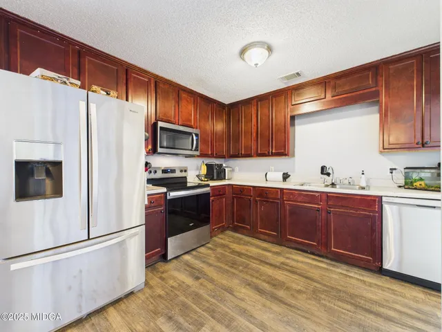 a kitchen with granite countertop wooden cabinets and sink