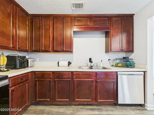 a kitchen with stainless steel appliances a refrigerator and a stove top oven