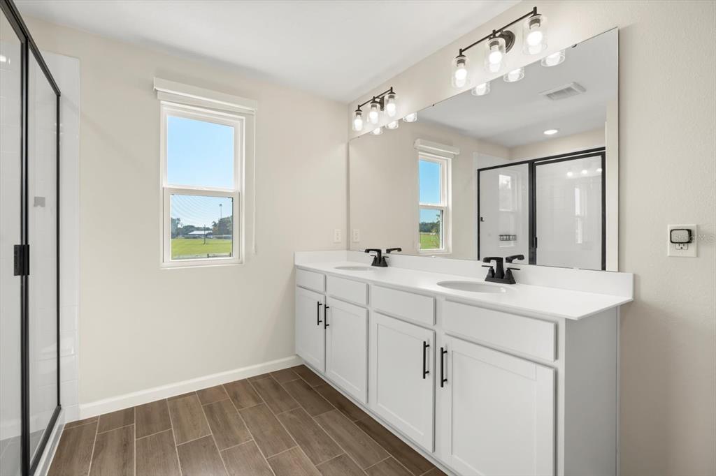 3657 Sublett Loop Tavares, FL 32778 - Photo 14 of 39 a bathroom with a sink double vanity granite and a mirror