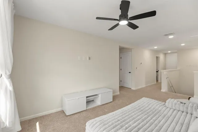 a bedroom with a bed and a ceiling fan