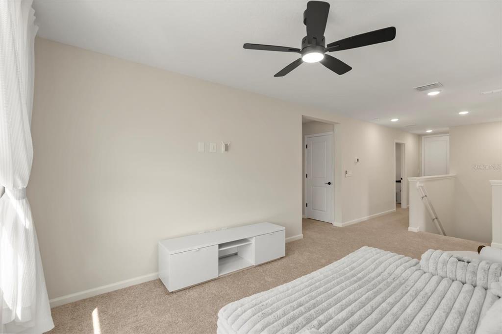 3657 Sublett Loop Tavares, FL 32778 - Photo 18 of 39 a bedroom with a bed and a ceiling fan