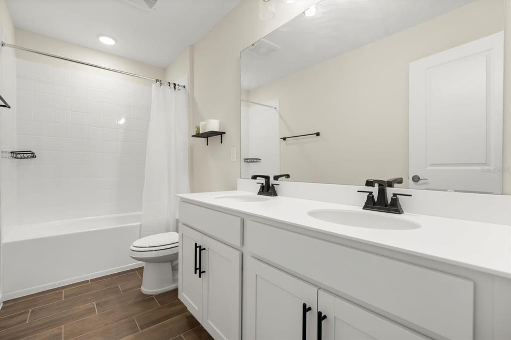 3657 Sublett Loop Tavares, FL 32778 - Photo 24 of 39 a bathroom with a sink a toilet and a large mirror