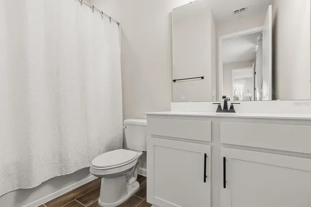 a bathroom with a sink a toilet and a mirror