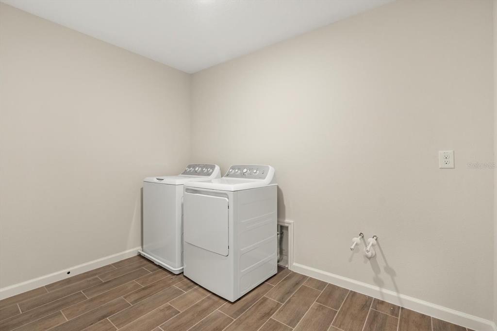 3657 Sublett Loop Tavares, FL 32778 - Photo 30 of 39 a utility room with wooden floor washer and dryer