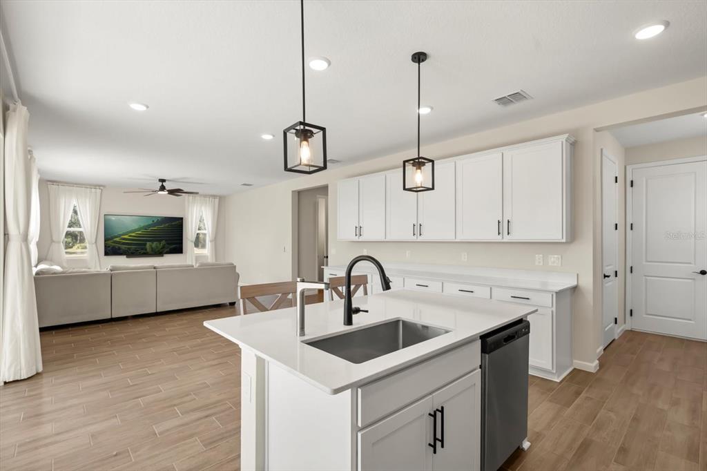 3657 Sublett Loop Tavares, FL 32778 - Photo 7 of 39 a kitchen with a sink a counter space and a view of living room