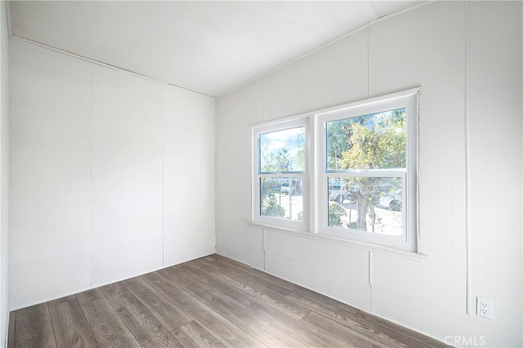 9106 Kennedy Street Riverside, CA 92509 - Photo 8 of 24 an empty room with wooden floor and windows