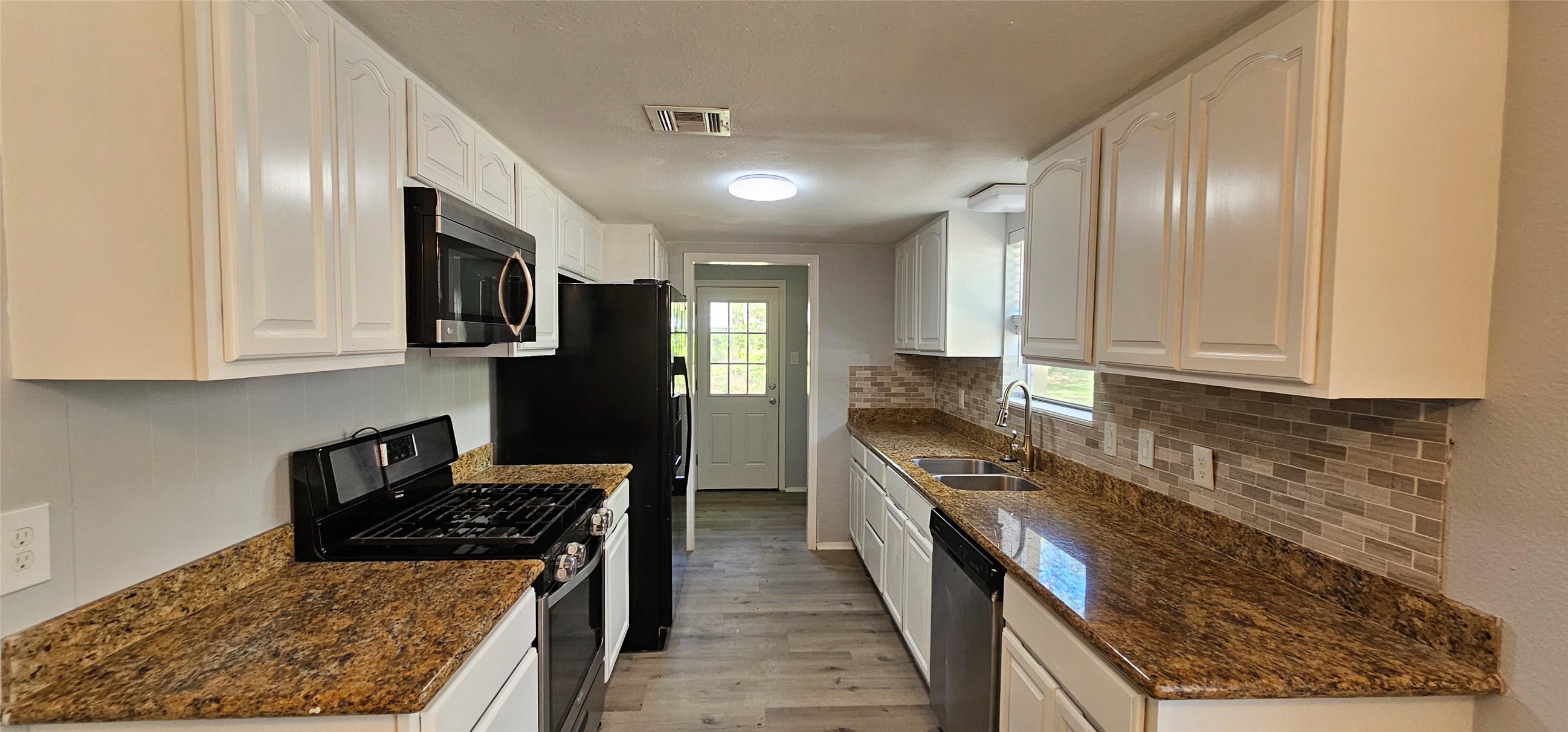 26311 Maplewood Drive Spring, TX 77386 - Photo 7 of 23 a kitchen with granite countertop stainless steel appliances and wooden cabinets