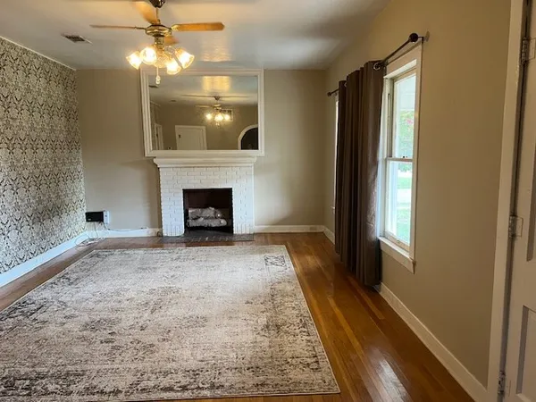 an empty room with windows and fireplace