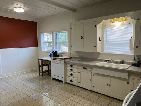 a kitchen with granite countertop white cabinets and white appliances