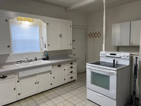 a kitchen with granite countertop a stove a sink and a refrigerator