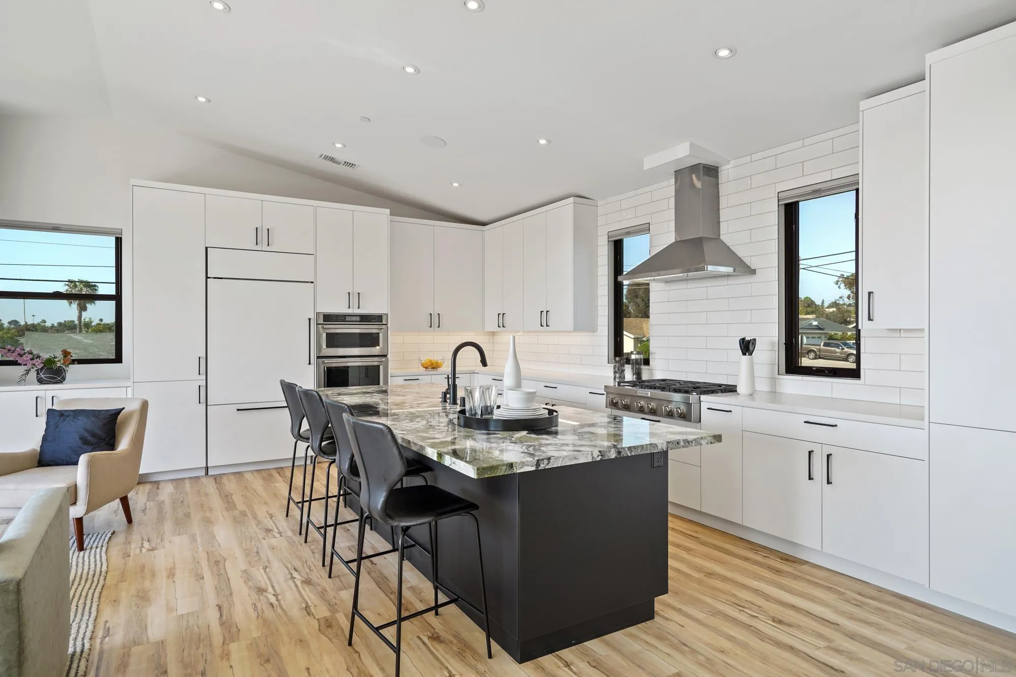 1604 Legaye Drive Cardiff, CA 92007 - Photo 17 of 42 a kitchen with stainless steel appliances kitchen island granite countertop a sink a stove a dining table and chairs