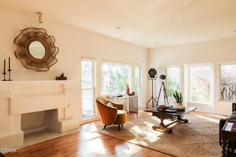 a living room with furniture a fireplace and a large window