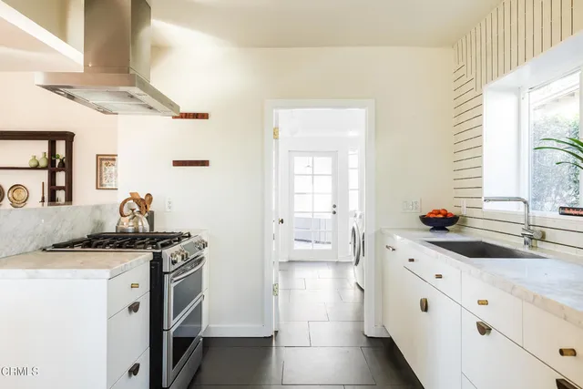 a kitchen with white cabinets and a window