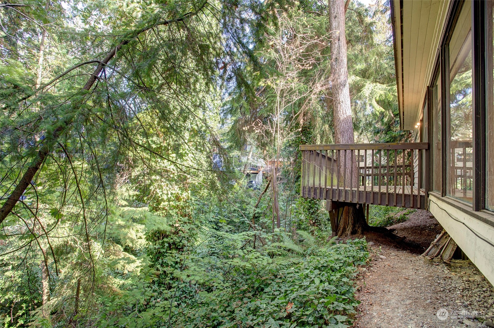 4604 Southwest Wildwood Place Seattle, WA 98136 - Photo 11 of 32 a view of a wooden deck with large trees and wooden fence