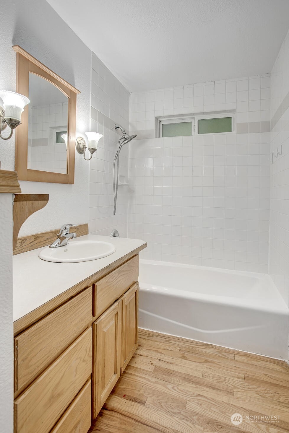 4604 Southwest Wildwood Place Seattle, WA 98136 - Photo 13 of 32 a bathroom with a sink a mirror and a bathtub