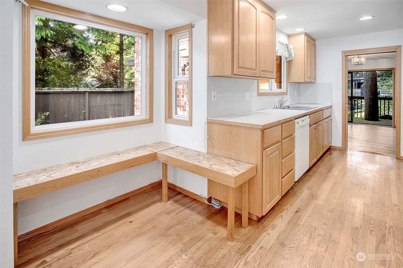 4604 Southwest Wildwood Place Seattle, WA 98136 - Photo 19 of 32 a white kitchen with wooden floor and large window