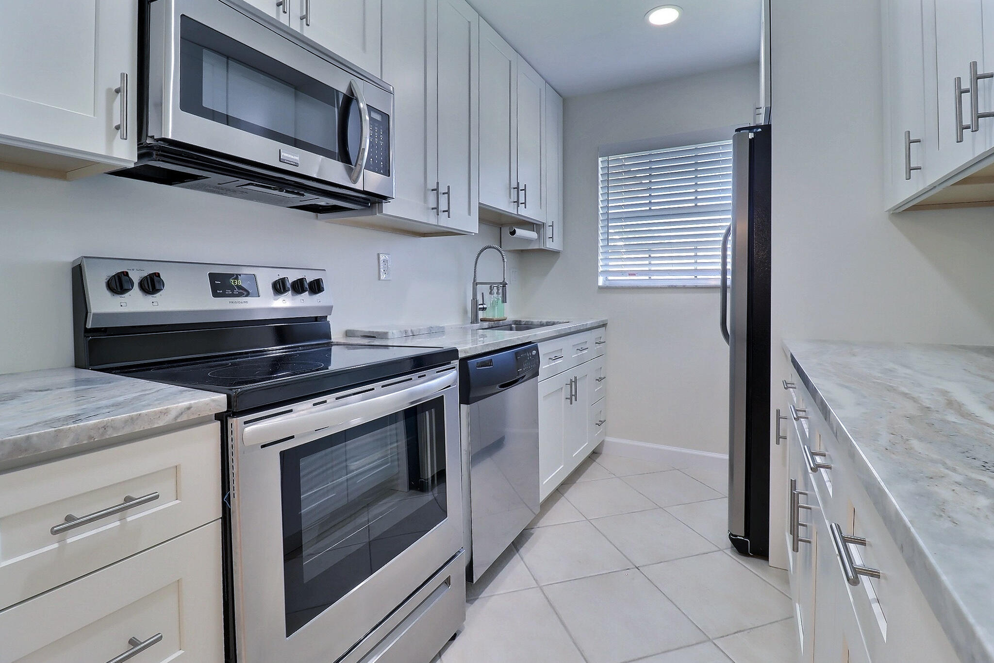 a kitchen with granite countertop cabinets stainless steel appliances and a sink