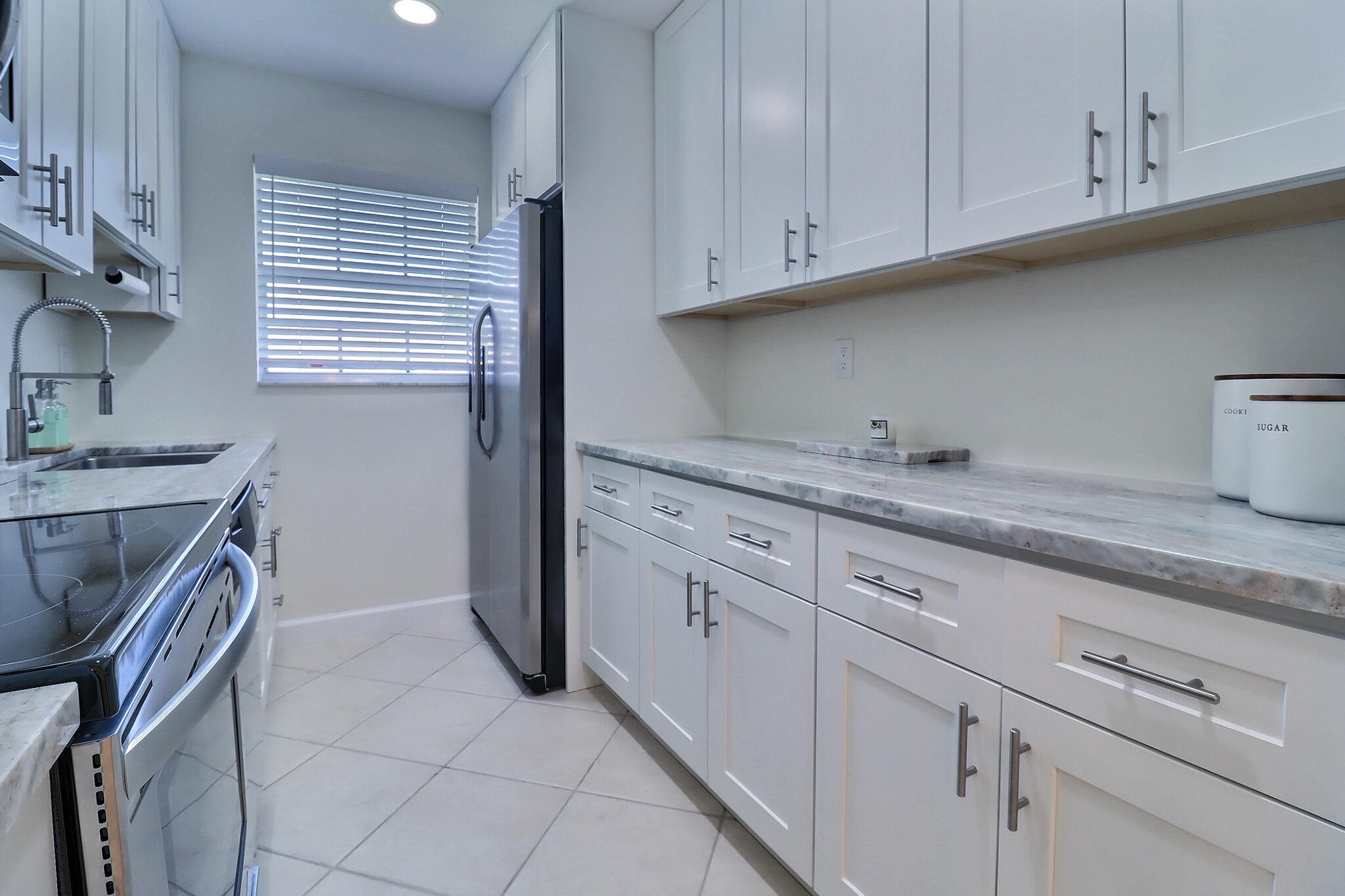 1330 High Point Place North, Unit C Delray Beach, FL 33445 - Photo 5 of 20 a kitchen with granite countertop white cabinets and white appliances