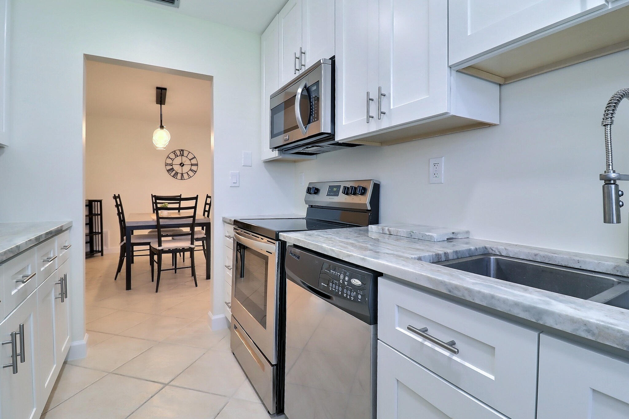 1330 High Point Place North, Unit C Delray Beach, FL 33445 - Photo 6 of 20 a kitchen with stainless steel appliances granite countertop a sink and cabinets