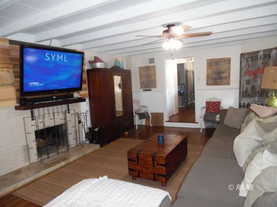 1355 South Mahan Street Ridgecrest, CA 93555 - Photo 9 of 35 a living room with furniture a fireplace and a flat screen tv