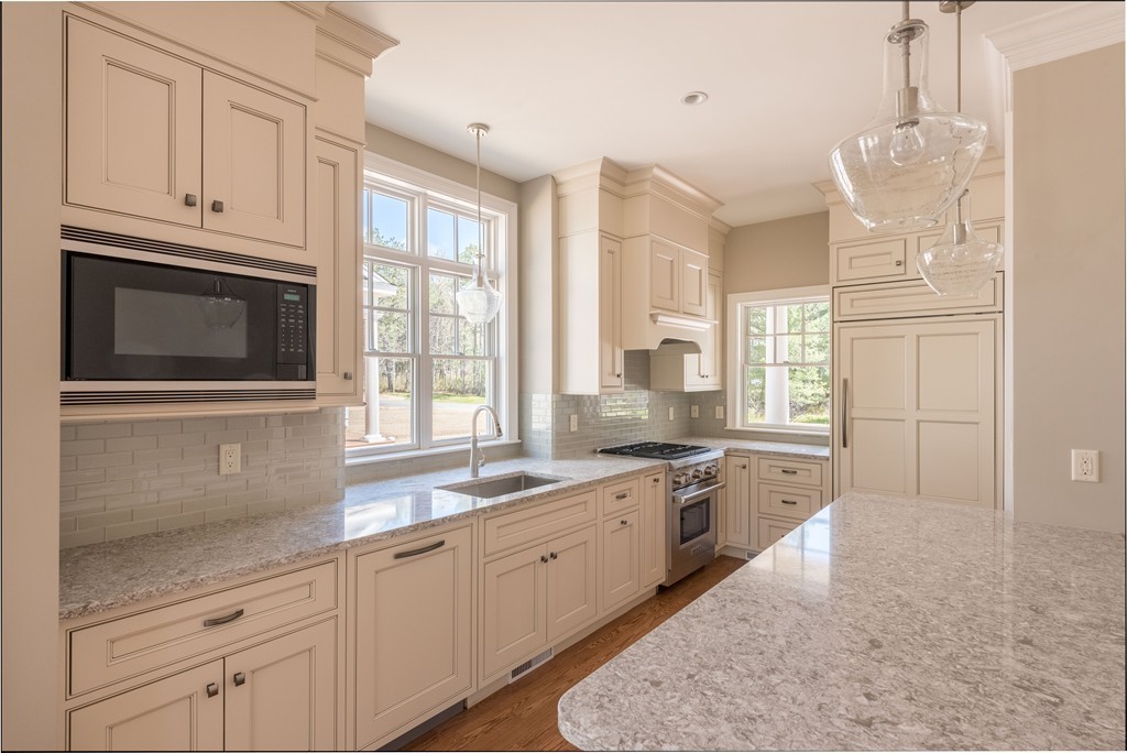 40 Clayton Circle, Unit B Mashpee, MA 02649 - Photo 5 of 12 a kitchen with granite countertop white cabinets stainless steel appliances a sink and a window