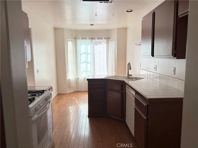 a kitchen with granite countertop a sink stove and refrigerator