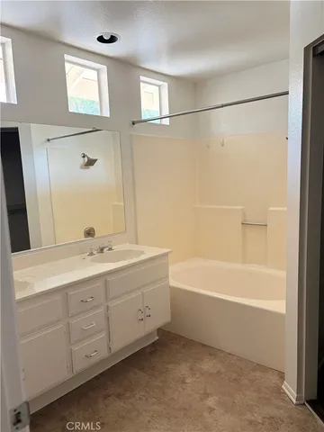 a bathroom with a tub sink and mirror