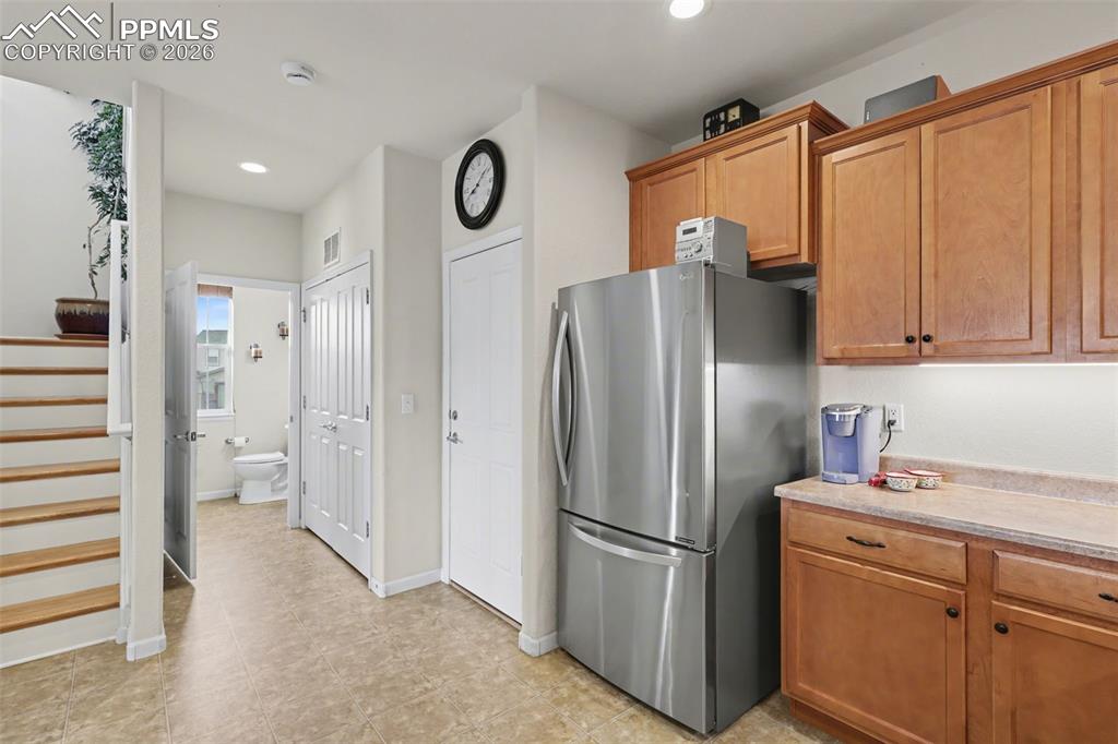 17063 Blue Mist Grove Monument, CO 80132 - Photo 9 of 33 a kitchen with stainless steel appliances a refrigerator a sink and cabinets