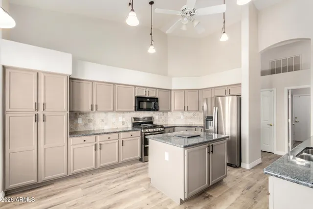 a kitchen with granite countertop a sink stainless steel appliances and cabinets