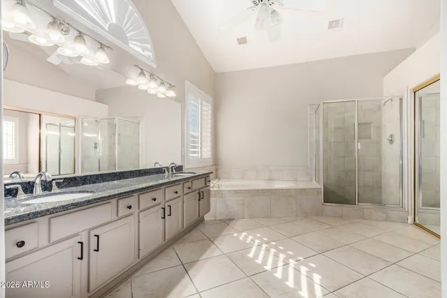 a large bathroom with a granite countertop sink a mirror and a bathtub