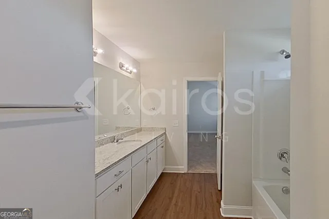 a bathroom with a granite countertop sink a mirror and shower