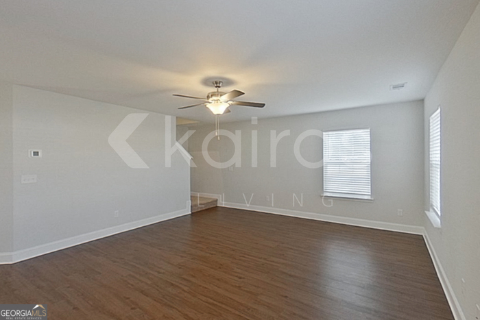 103 Western Red Cedar Drive Springfield, GA 31329 - Photo 2 of 24 an empty room with wooden floor chandelier fan and windows