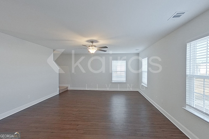 103 Western Red Cedar Drive Springfield, GA 31329 - Photo 3 of 24 an empty room with wooden floor chandelier fan and windows