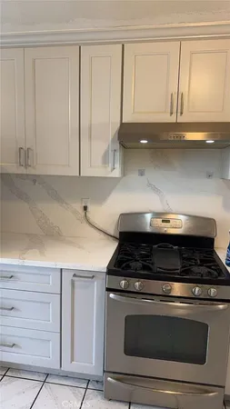 a stove top oven sitting inside of a kitchen