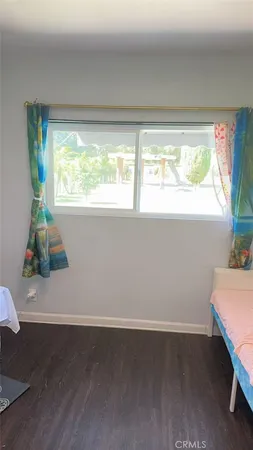 a view of a room with wooden floor and a window