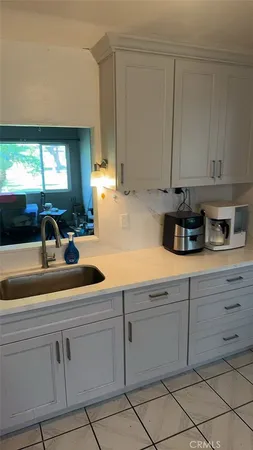 a kitchen with white cabinets and a sink