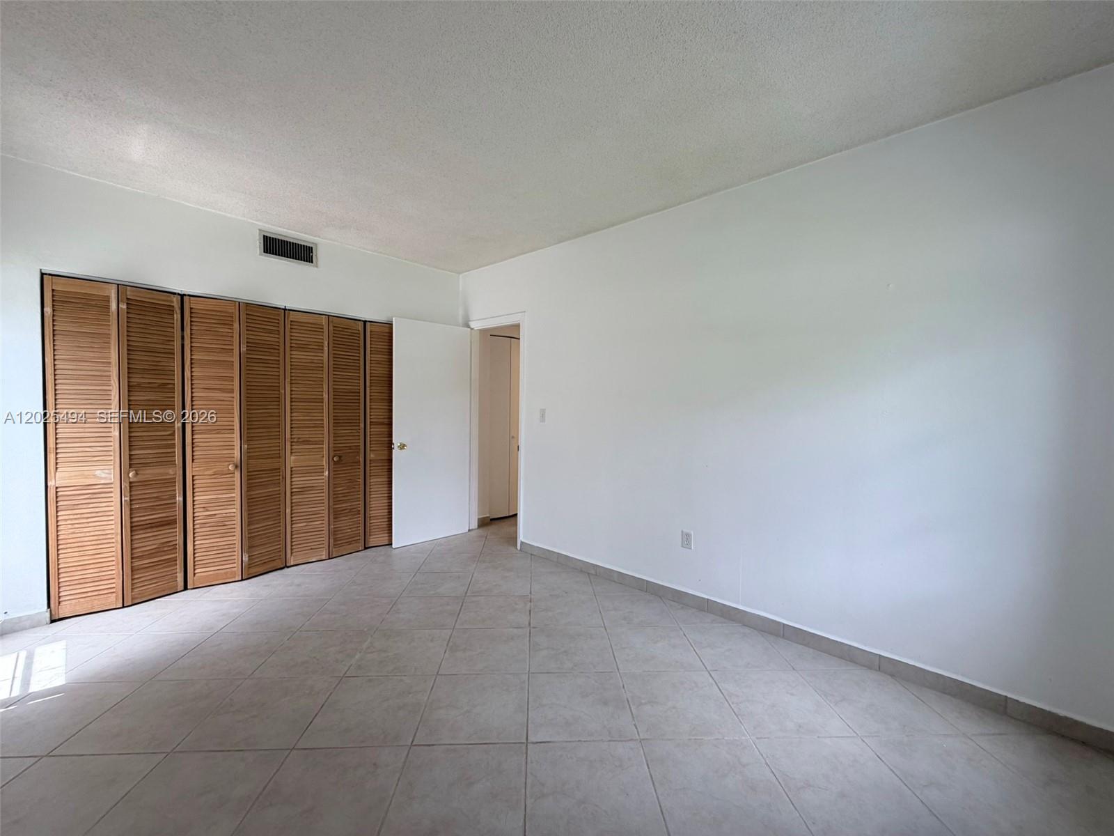 9159 Southwest 77th Avenue, Unit 112 Miami, FL 33156 - Photo 23 of 38 a view of an empty room with a window