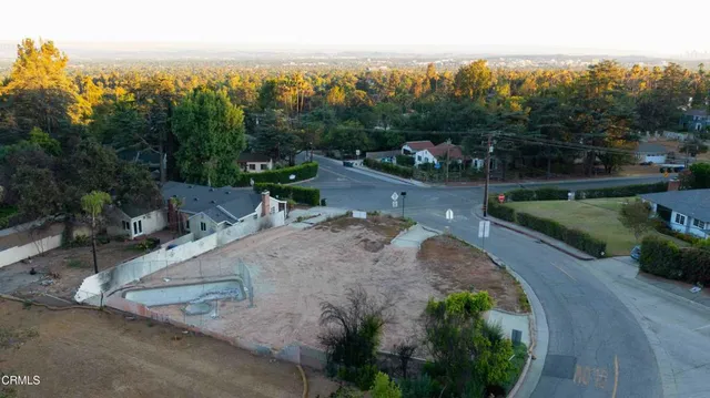 an aerial view of a house with a yard and lake view in back