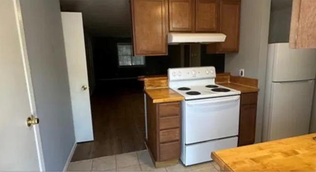 a kitchen with a refrigerator and a stove