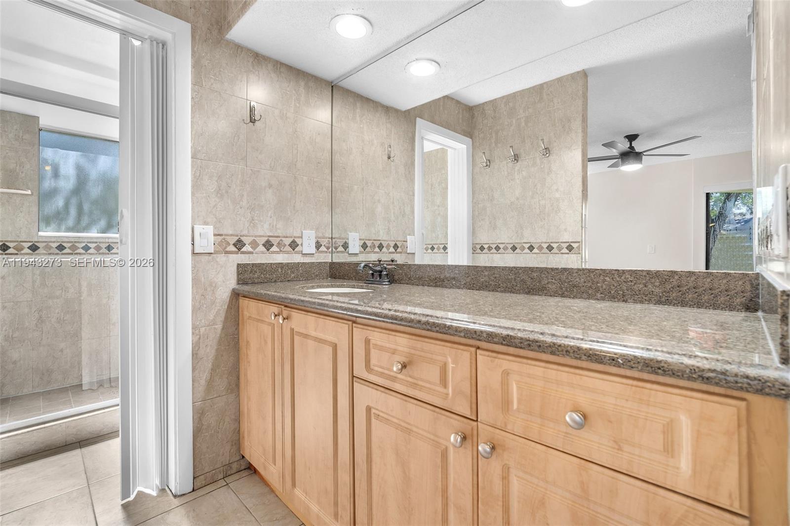 1618 Northwest 81st Way, Unit 1618 Plantation, FL 33322 - Photo 29 of 38 a bathroom with a granite countertop sink mirror and