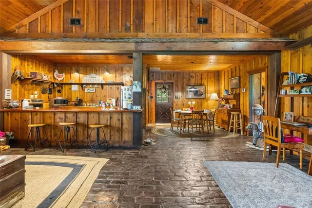 a kitchen with stainless steel appliances kitchen island granite countertop a refrigerator oven a sink dishwasher and white cabinets with wooden floor